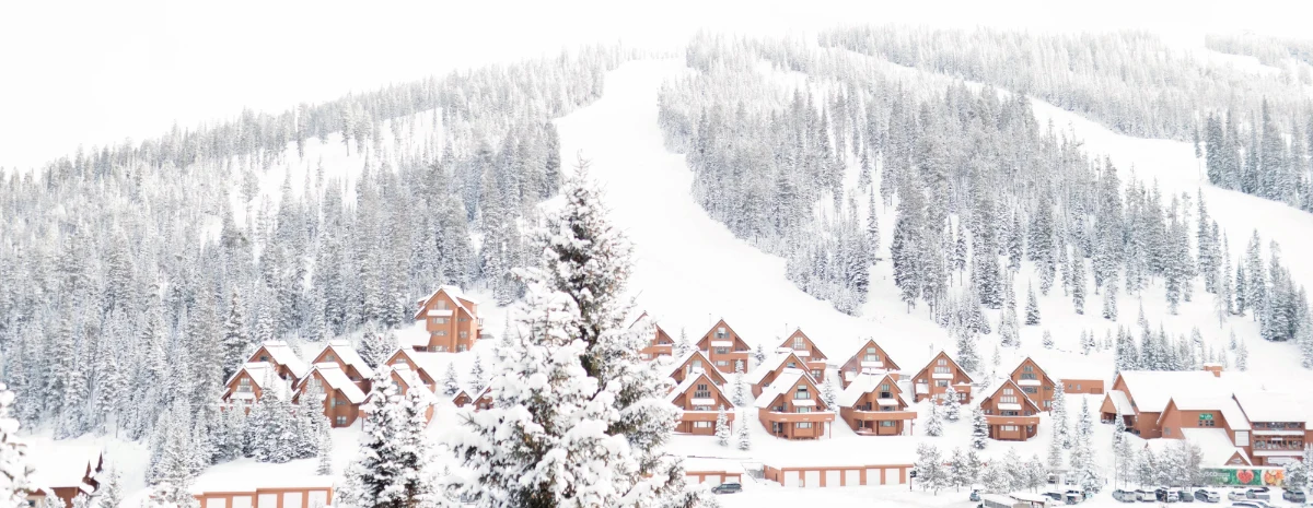 Snow-covered mountain slopes, evergreen trees, and lodges at Big Sky