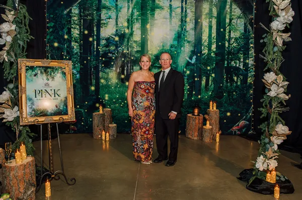 Guests posing beside forest decorations at Paint the Town PINK