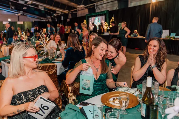 Guests cheering at their dinner table at Paint the Town PINK