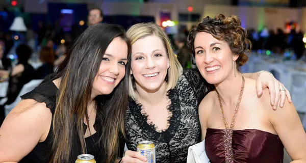 Three guests smiling together at Paint the Town PINK
