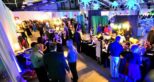 Guests gathering in the blue-lit event hall at Paint the Town PINK