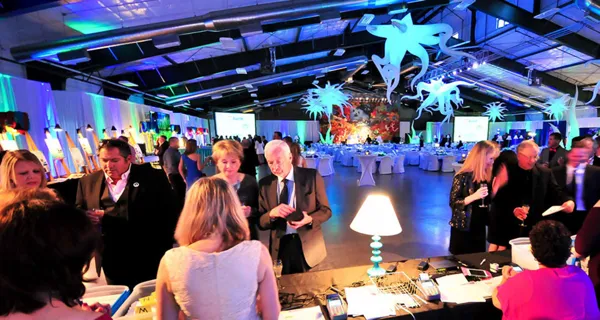 Guests seated at dinner under colorful lighting at Paint the Town PINK