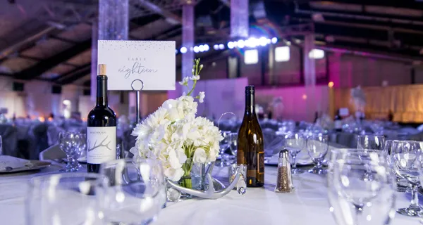 Purple-lit tables and floral centerpieces at Paint the Town PINK