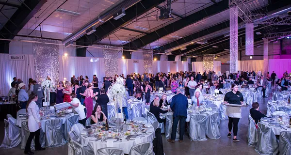 Guests seated in the purple-lit banquet hall at Paint the Town PINK