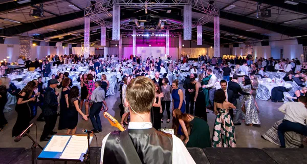 Crowd gathered under the event hall lights at Paint the Town PINK