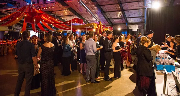 Guests beneath colorful ceiling drapes at Paint the Town PINK
