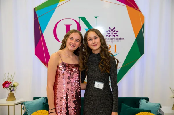 Two guests posing at the PINK photo backdrop at Paint the Town PINK
