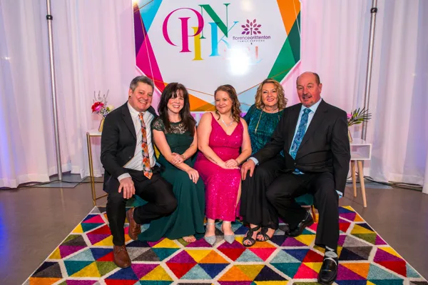 Group posing at the PINK photo backdrop at Paint the Town PINK