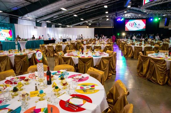 Banquet hall with rainbow table settings at Paint the Town PINK